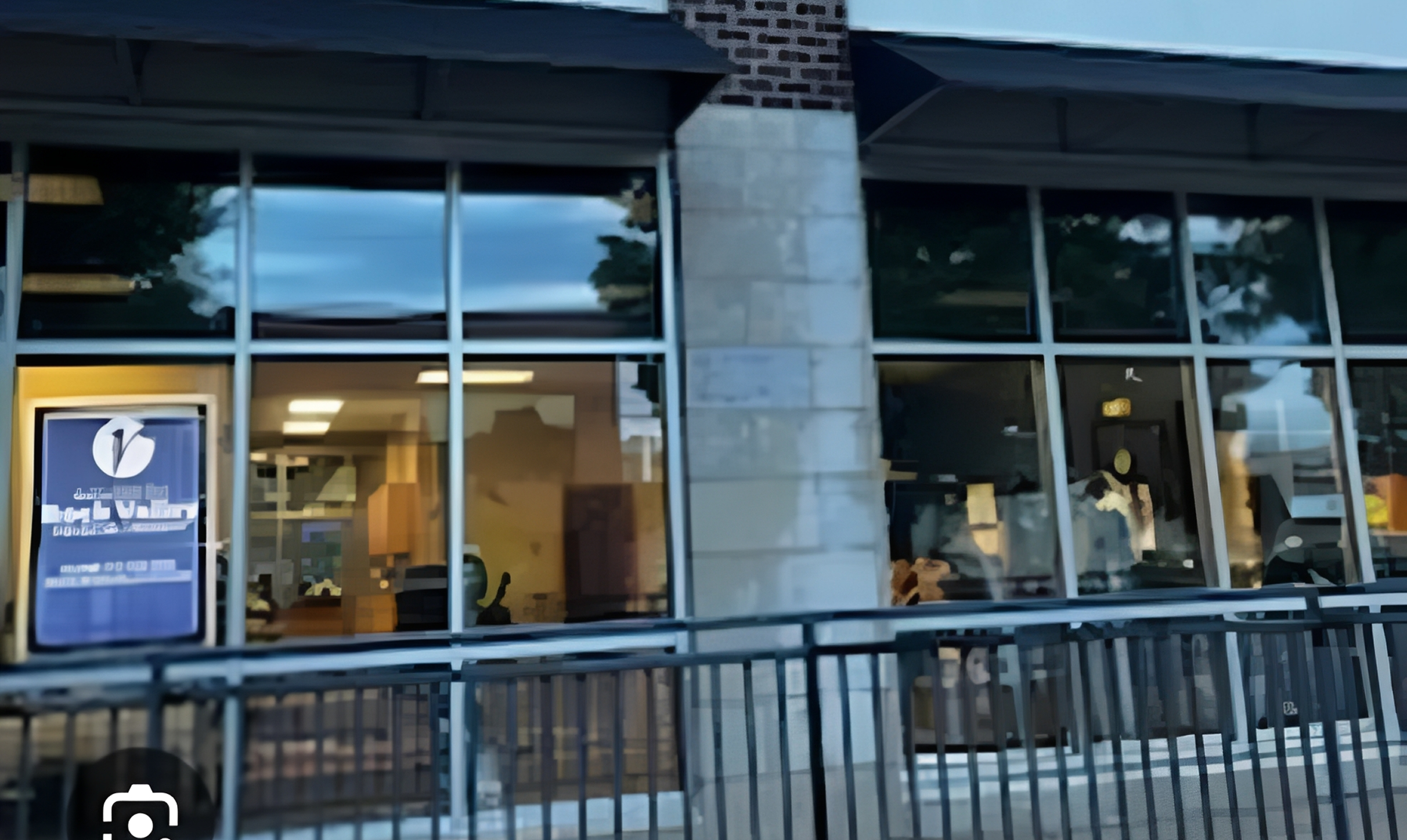 Brick building with glass windows and railing