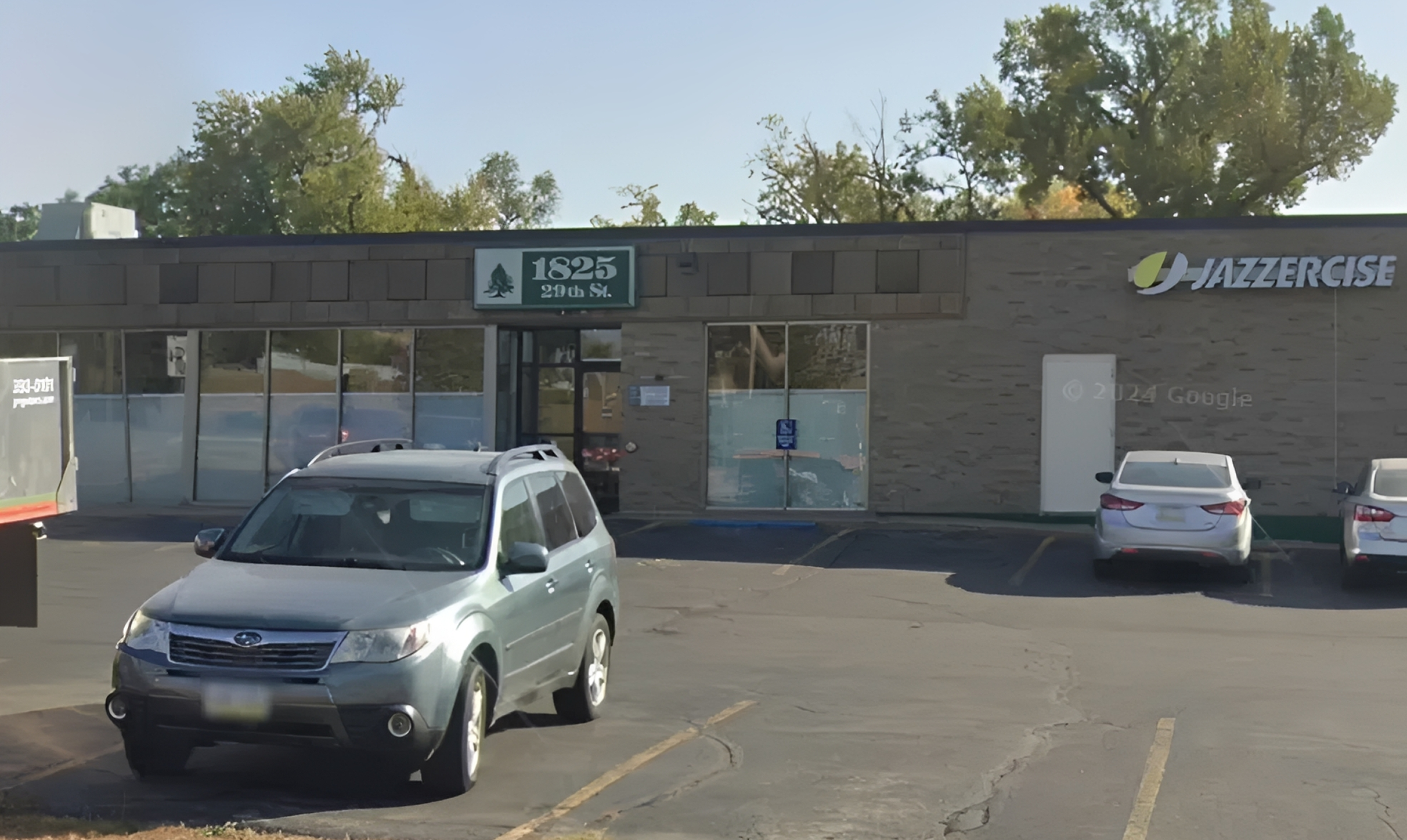 Fitness studio storefront with parked cars