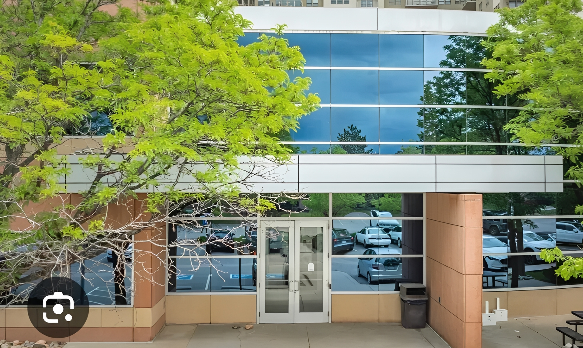 Tree-lined entrance to glass building